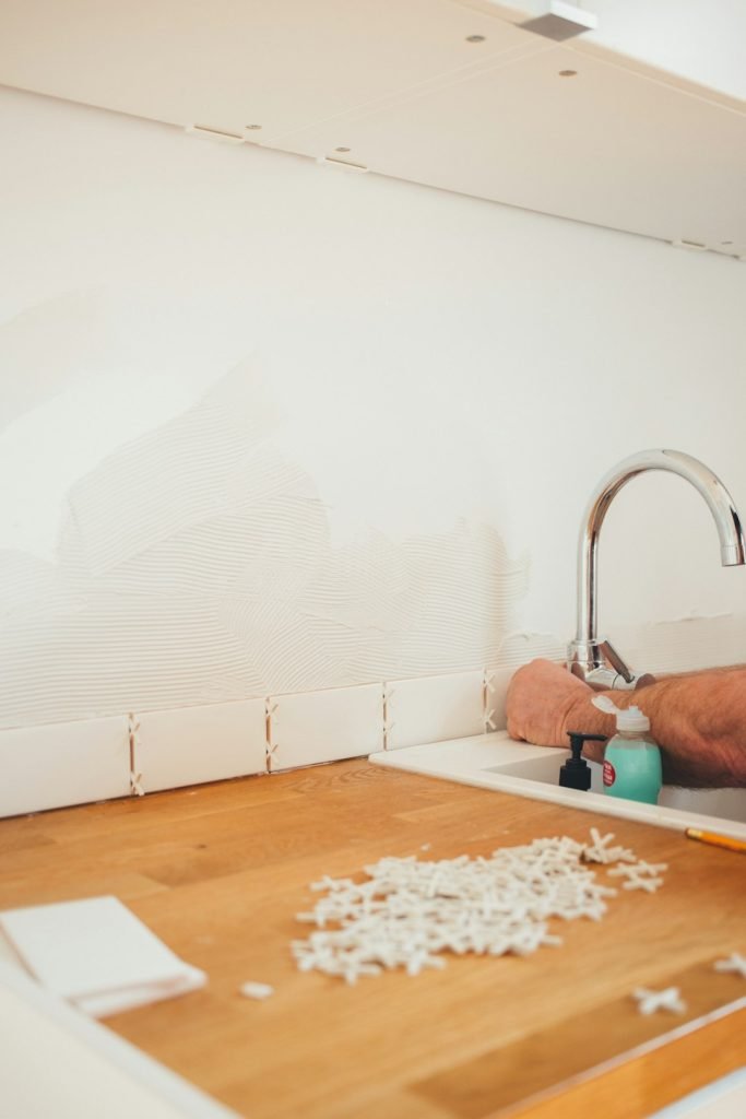 Michel the handyman is installing the kitchen tiles.